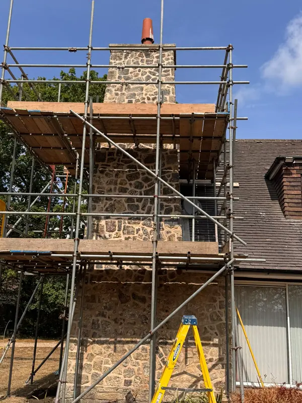Stone chimney with scaffolding during repointing